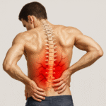 Illustration of a man experiencing lower back pain, shown from behind with his hands on his lower back. The spine is highlighted and overlaid with red and dark vein-like patterns to emphasize inflammation and pain in the lumbar region.